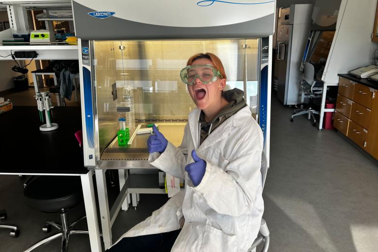 Jessica Rowe smiles in the lab while working on an experiment