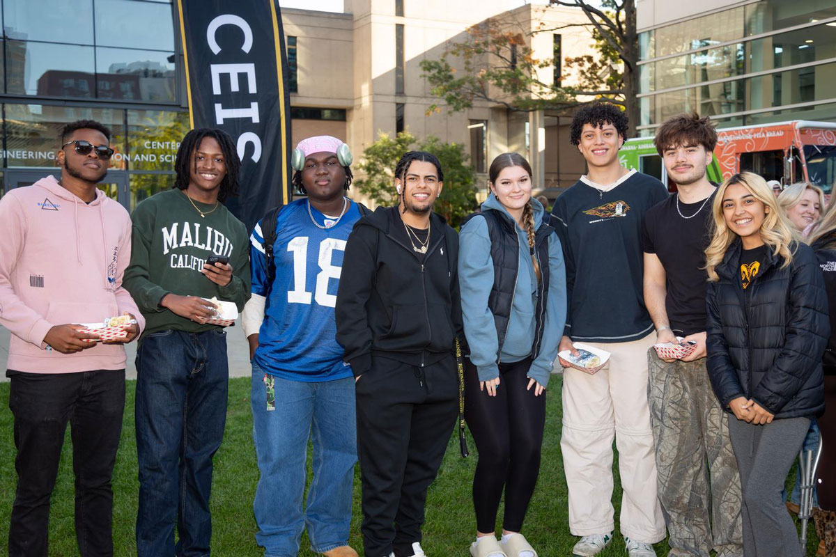A group of students from different backgrounds pose for the camera at Campus Fest