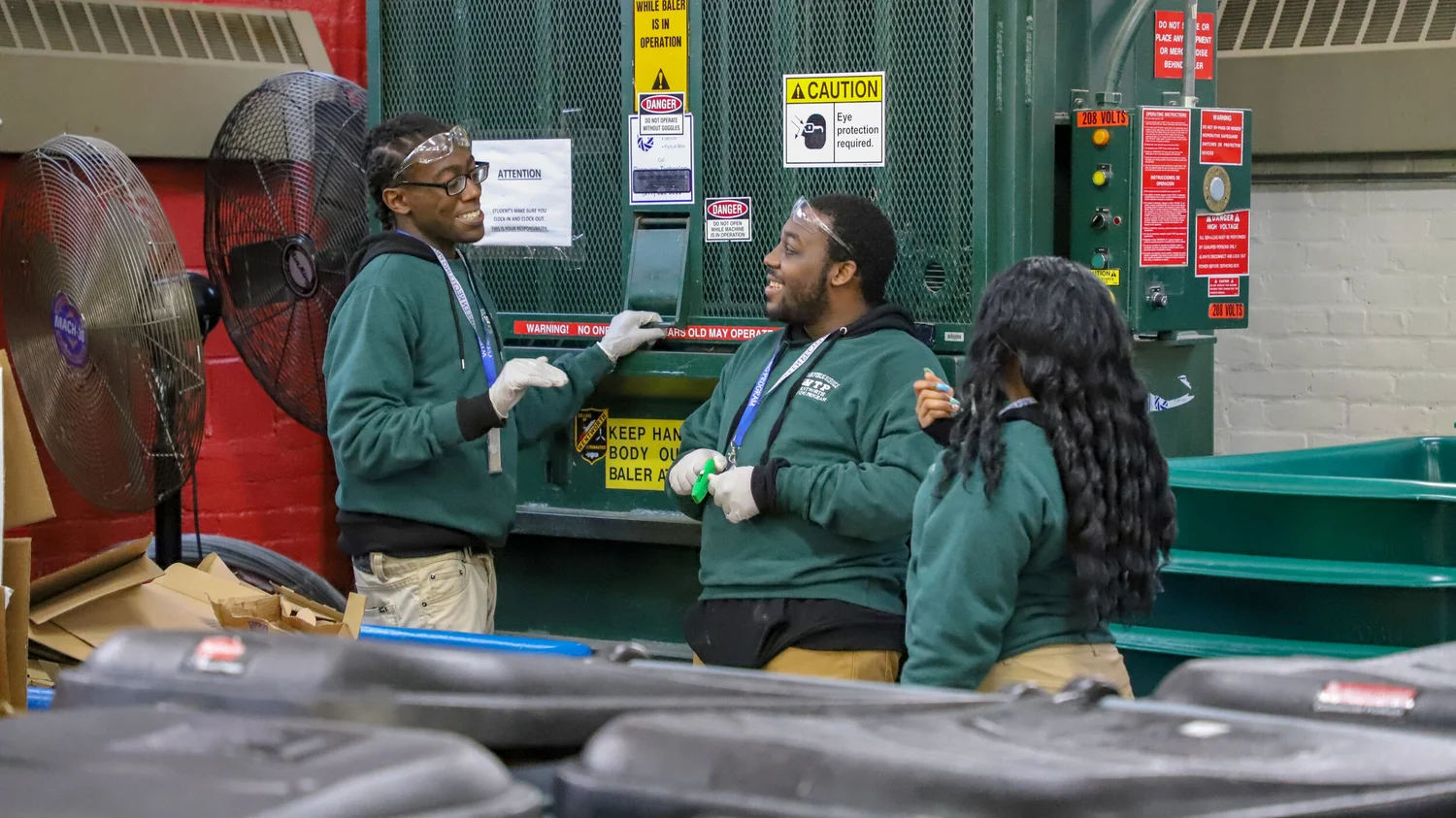 Three STRIVE students work in the recycling center