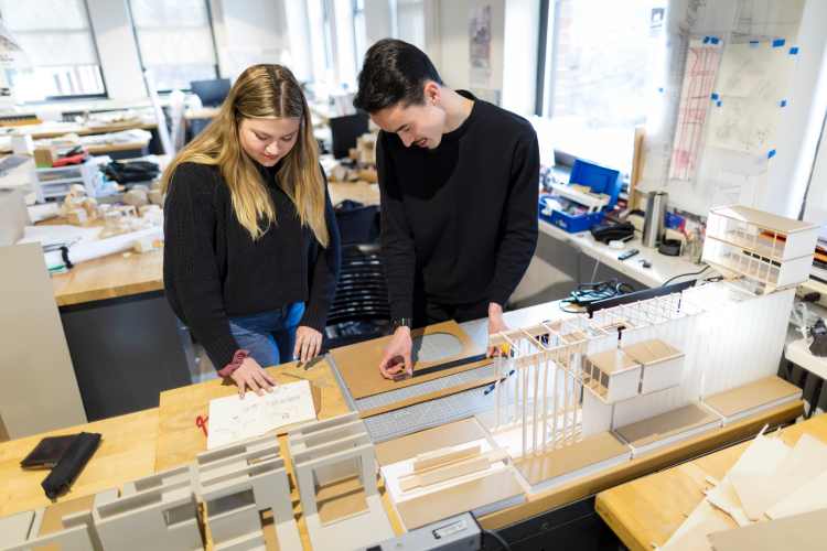 Students building a model building with paper