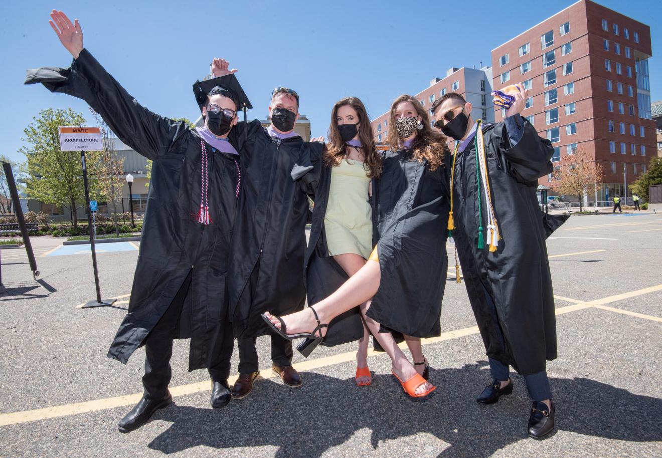 students in commencement gowns celebrating