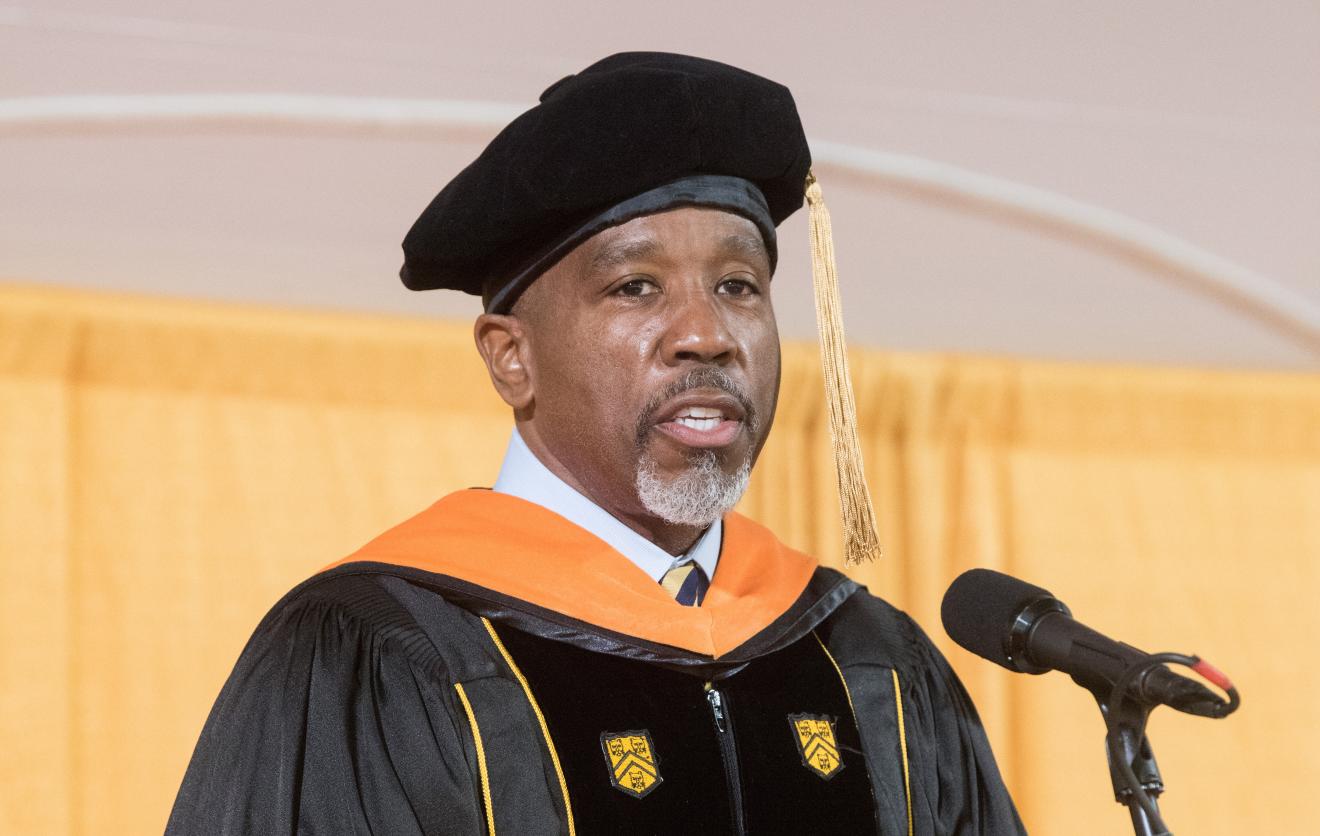 man speaking while wearing graduation cap