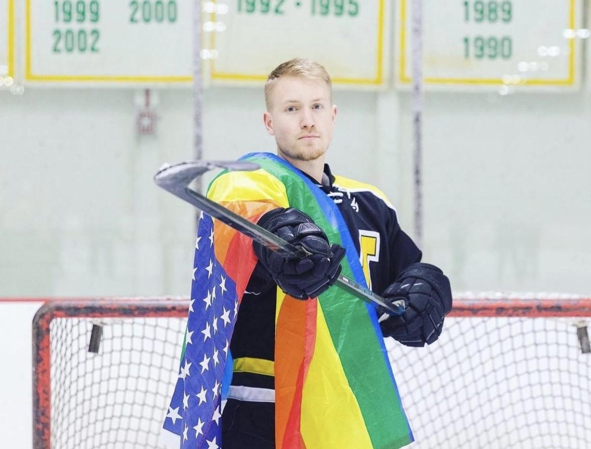 Hockey player holding a rainbow flag