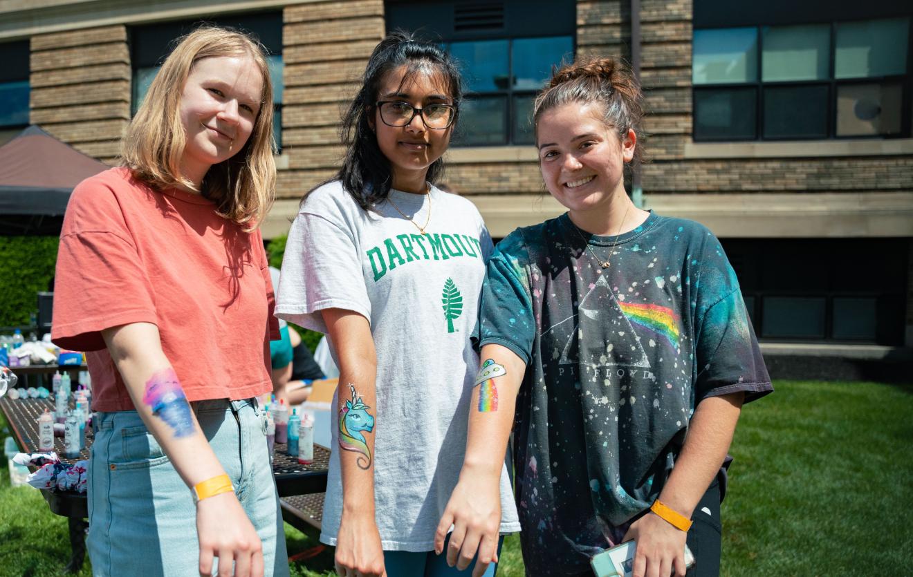 three women display temporary tattoos on arms