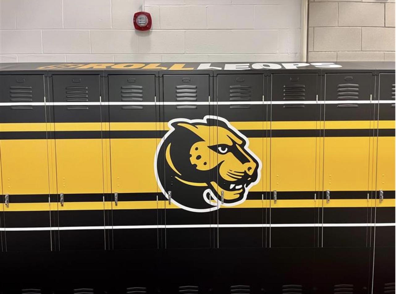 a series of yellow and black lockers in a locker room 