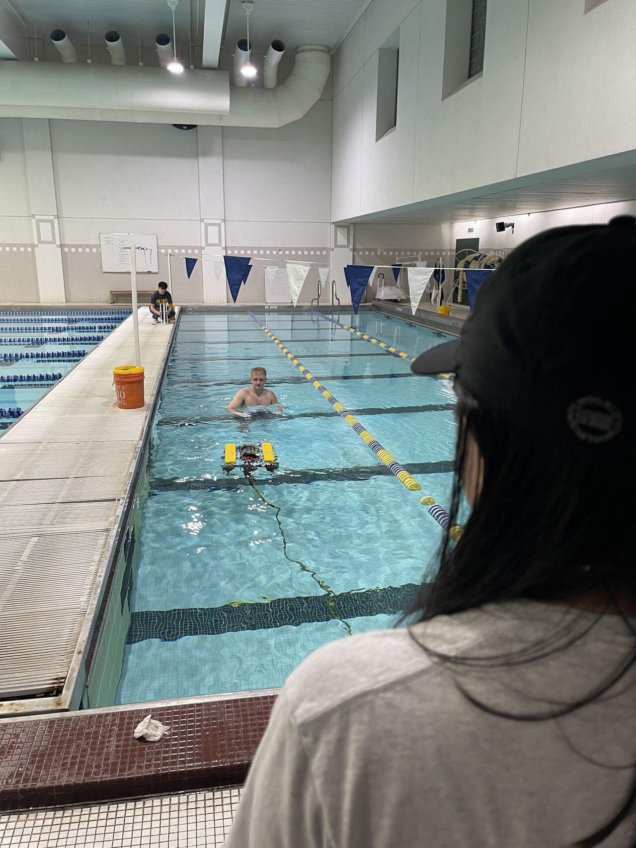 woman watches a robot in a swimming pool