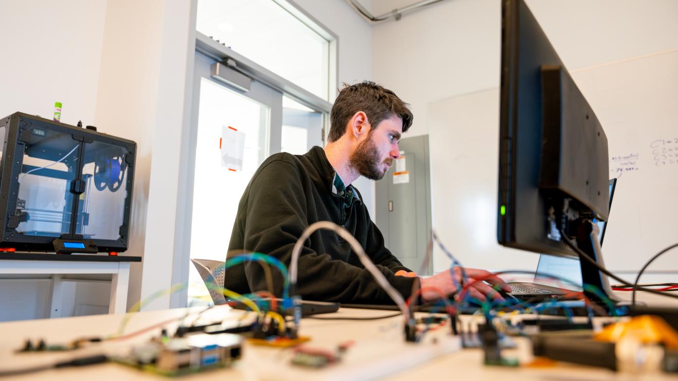 student working at a computer in an ai lab