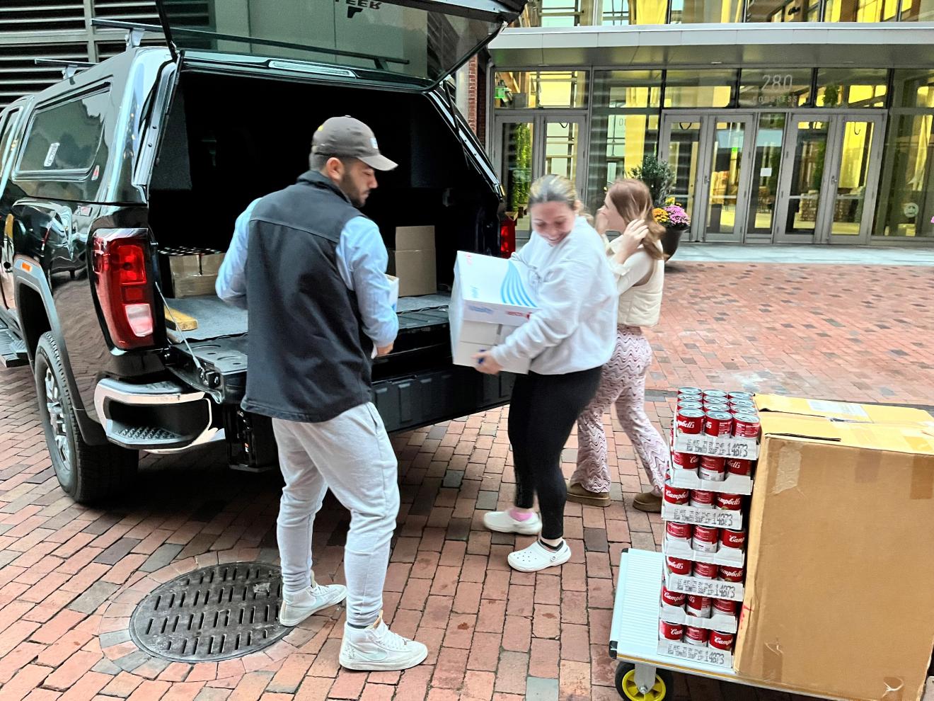 people taking cans out of a vehicle