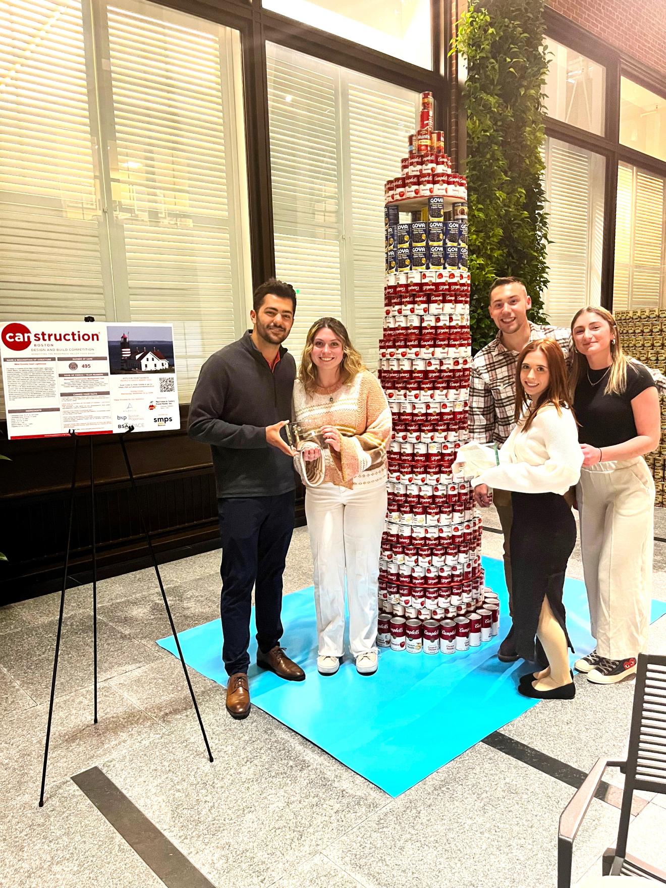 people standing next to a tower of cans