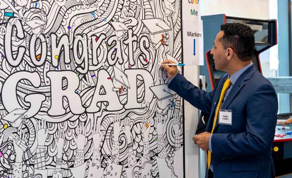 man signing his name on a large board