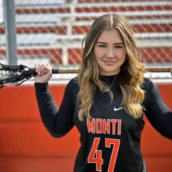 a woman holds a lacrosse stick
