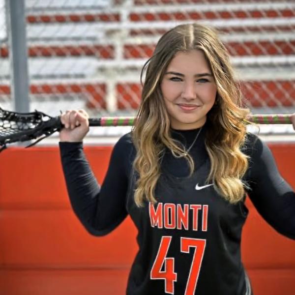 a woman holds a lacrosse stick