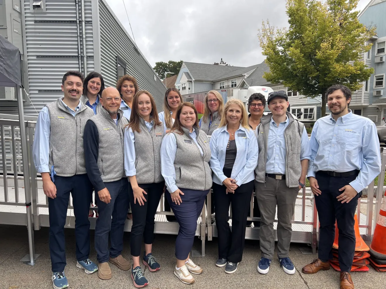 a group of people wearing grey vests