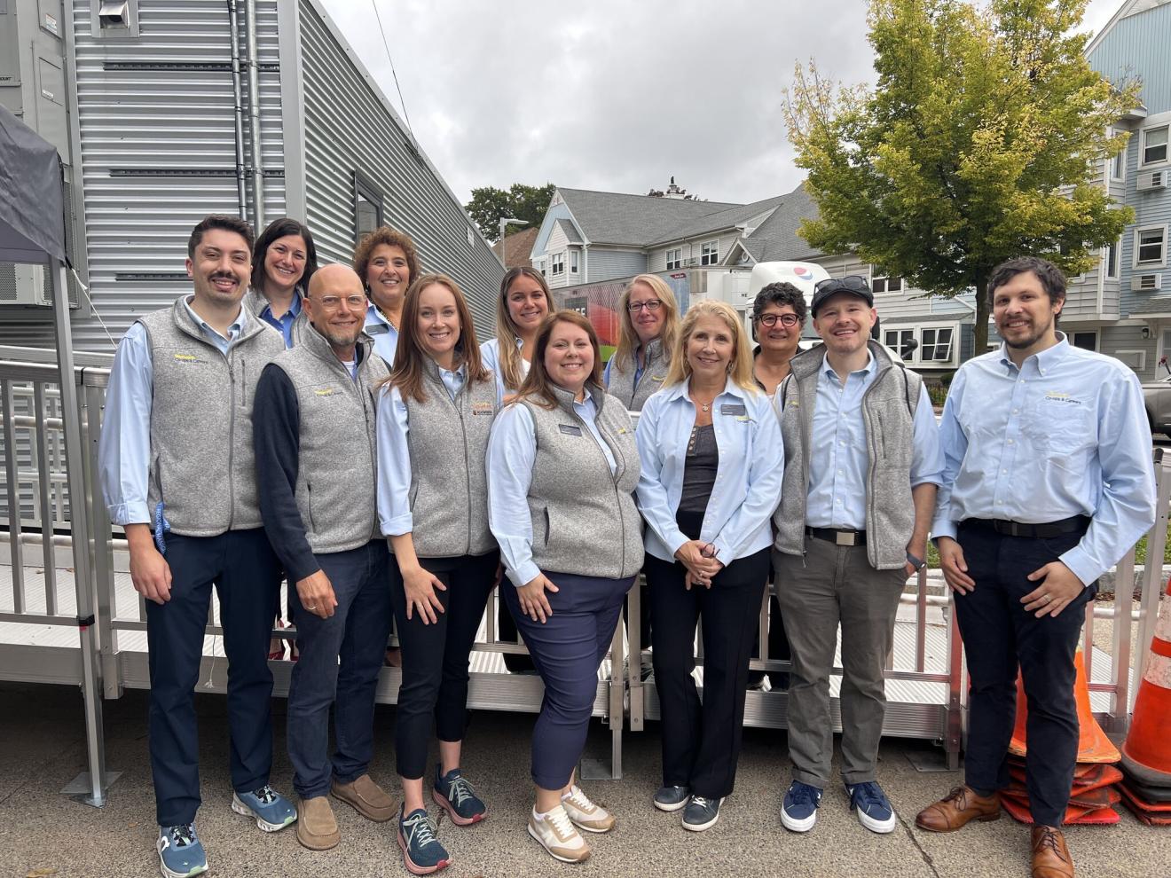 a group of people wearing grey vests