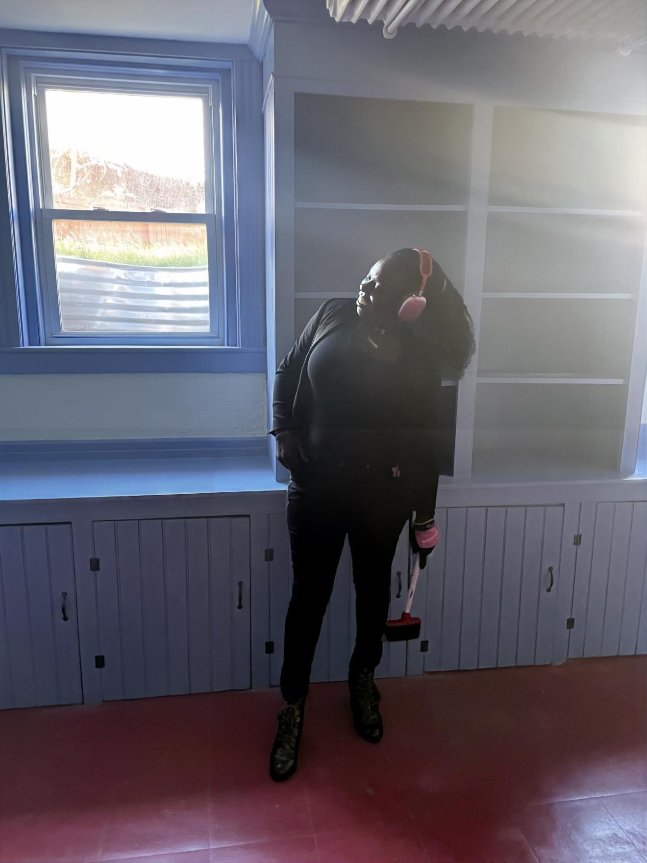 a woman stands in front of a window in a kitchen