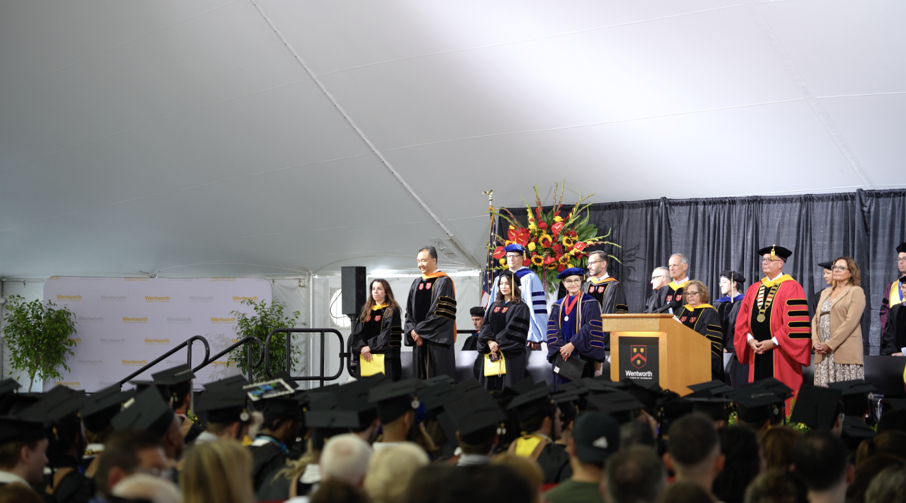 people gathered under a tent for a graduation ceremony