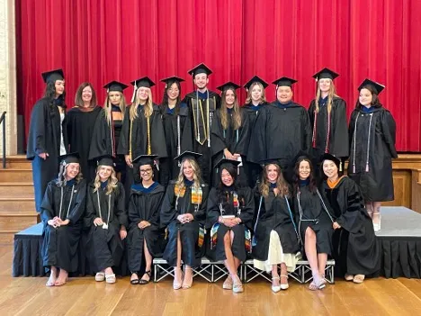 People posing while wearing graduation robes and caps