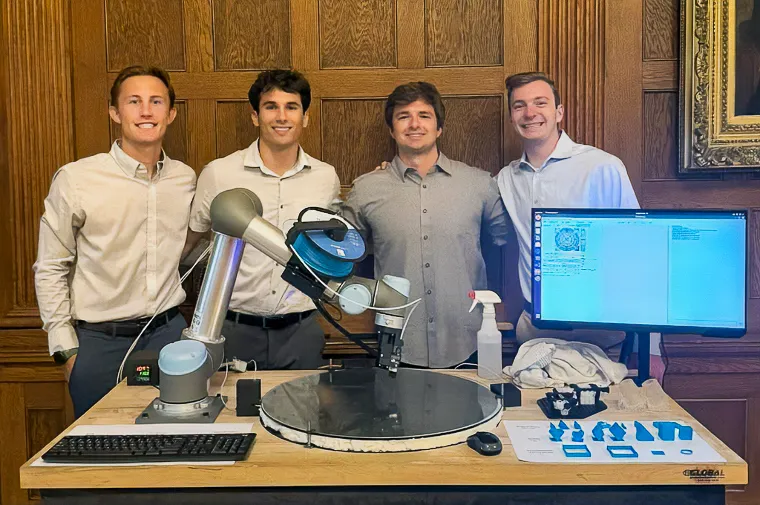 a team of students stand with a robotic arm 3d printing system