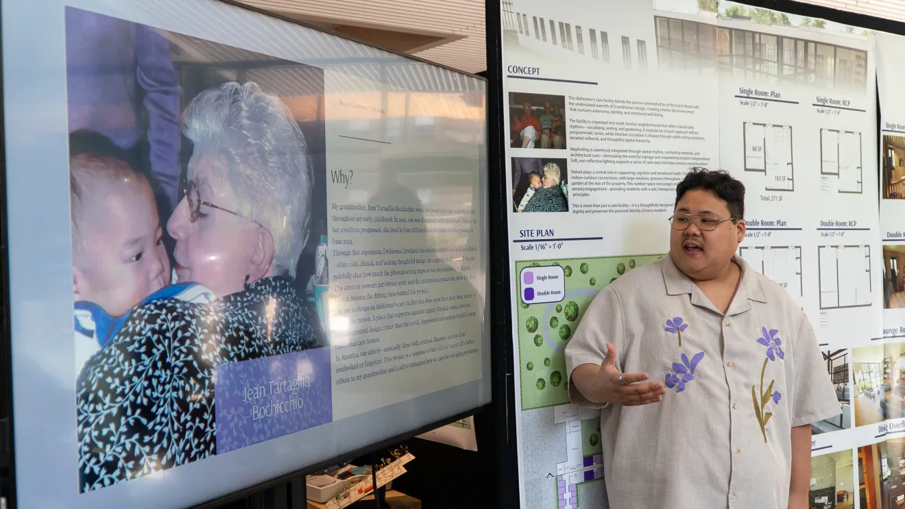 a student presents a project in front of a picture of his grandmother