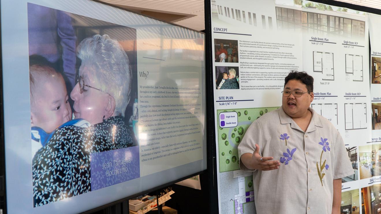 a student presents a project in front of a picture of his grandmother
