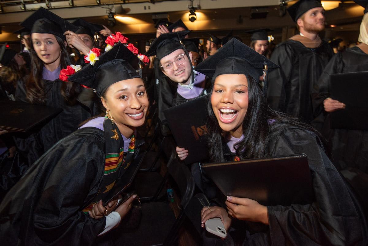 happy students smile while wearing greaduation robes