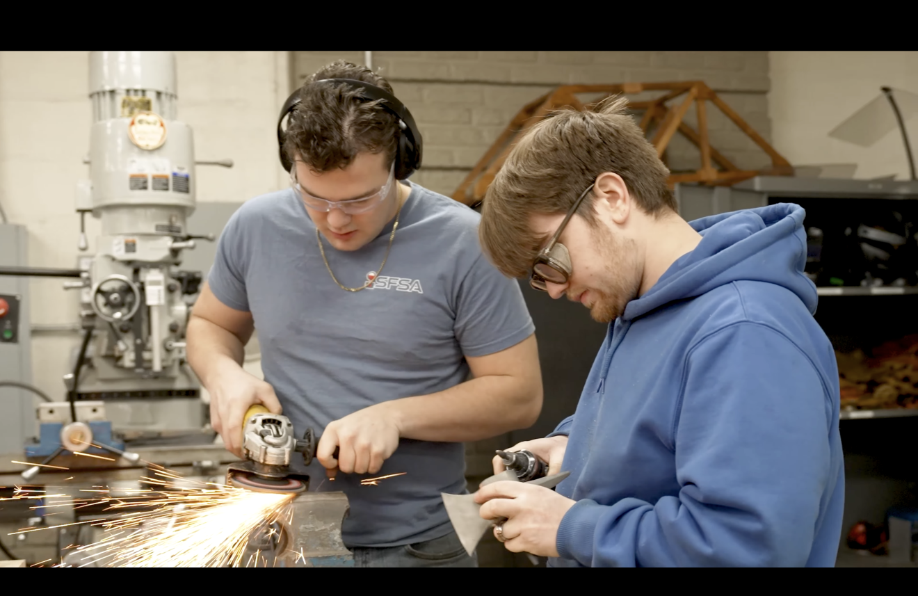 two students casting a steel axe