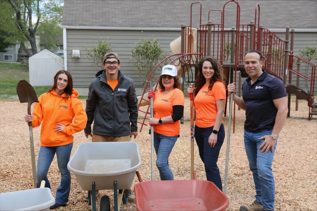 several people wearing bright orange shirts at a build site