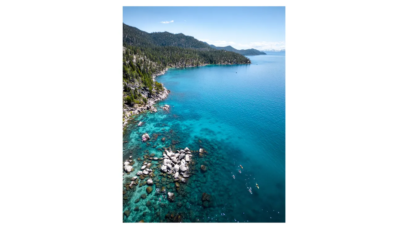 a bright blue lake next to mountains
