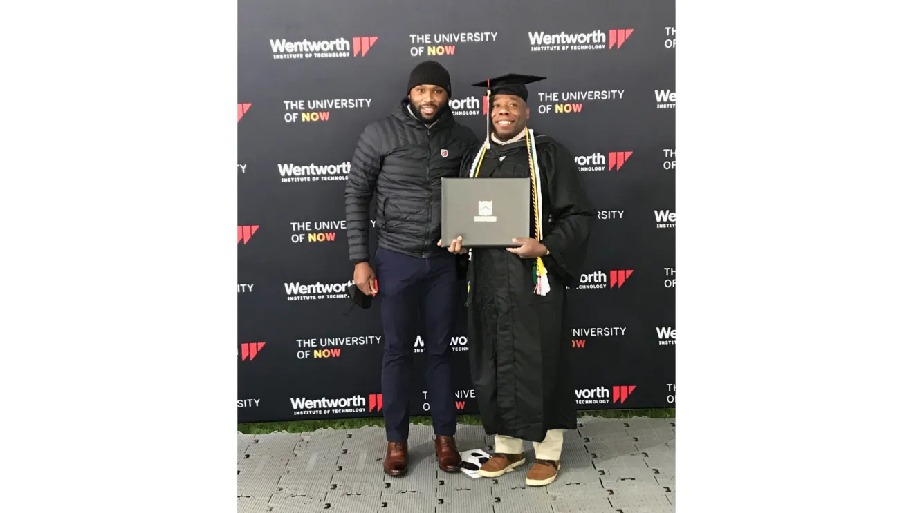 a man in a graduation cap stand with another man