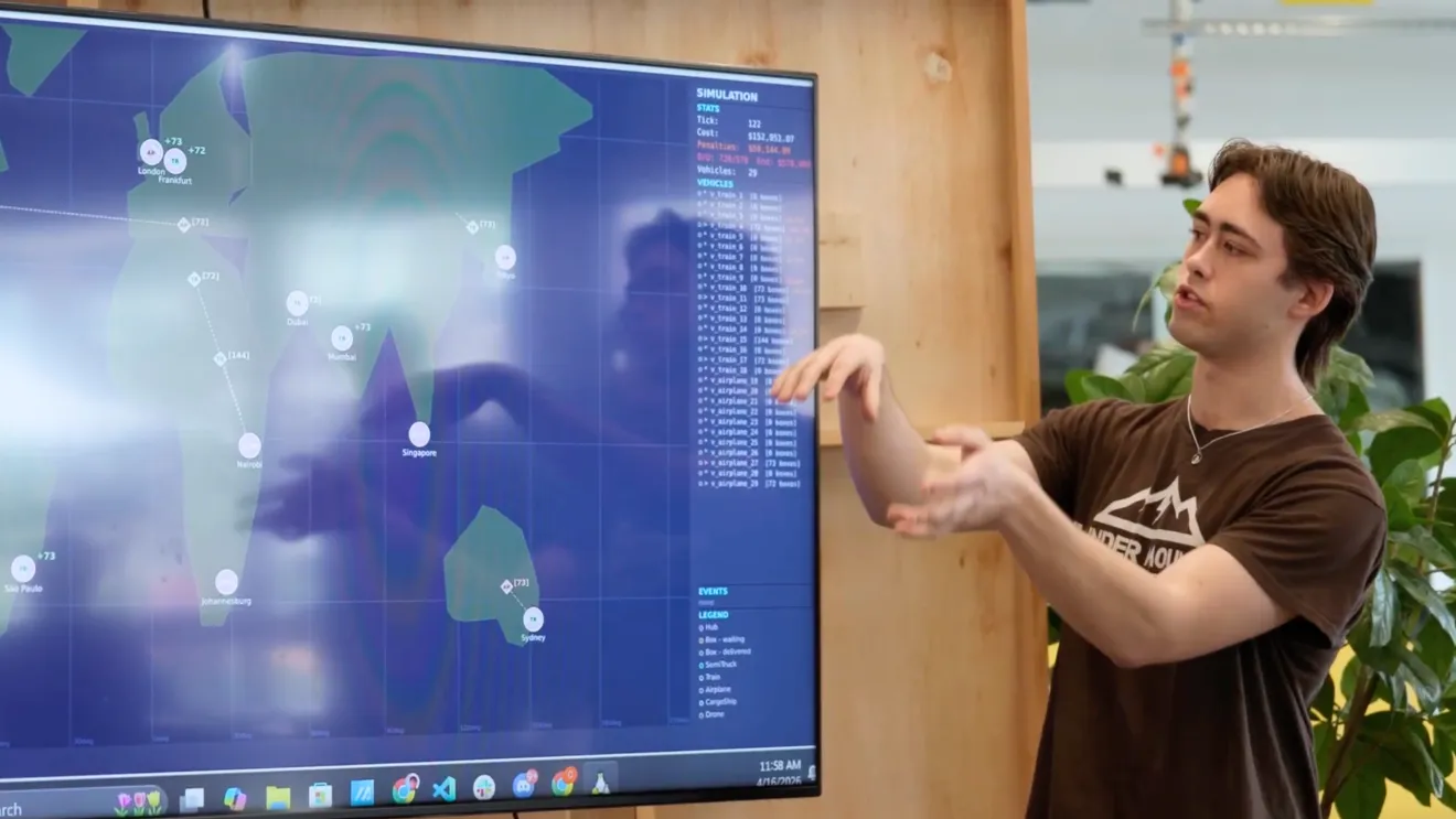 a student points to a screen to demonstrate a computer program