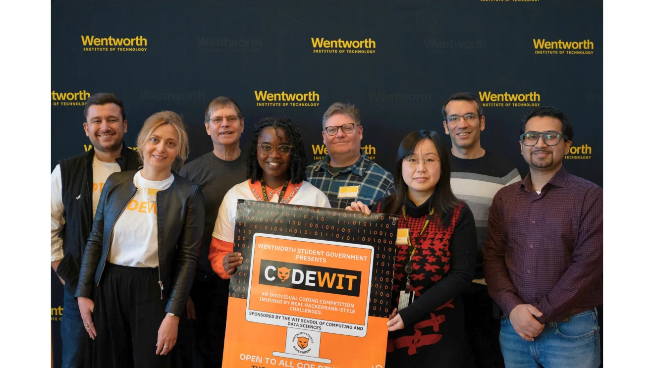 a group of people holding a sign that reads "coding at wit"