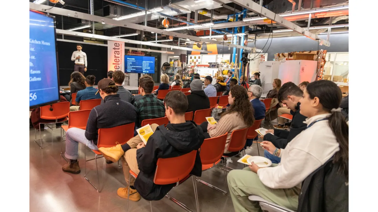 a person speaks to a room of students