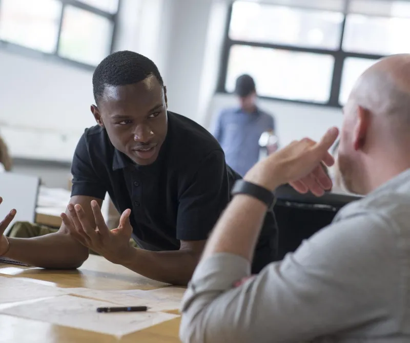 A student converses with a faculty member in the classroom