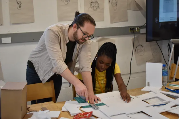 Student working with teacher on architecture model