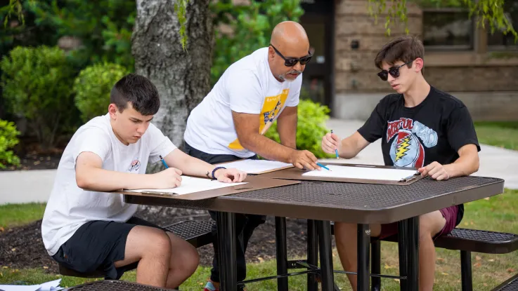 Students working with faculty outside on sketches