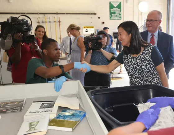 people shaking hands in a recycling facility
