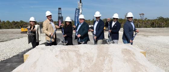 people in hard hats and holding shovels at a ceremony