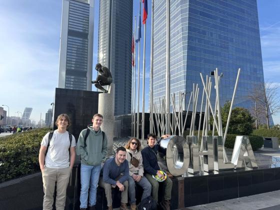 students sitting in front of a Spain skyscraper