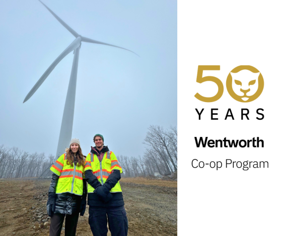 two students in front of a wind turbine