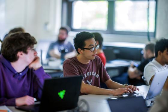A classroom of students works with hands-on computing projects