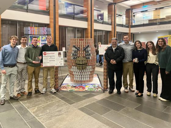 a large installation of cans sits next to a group of students