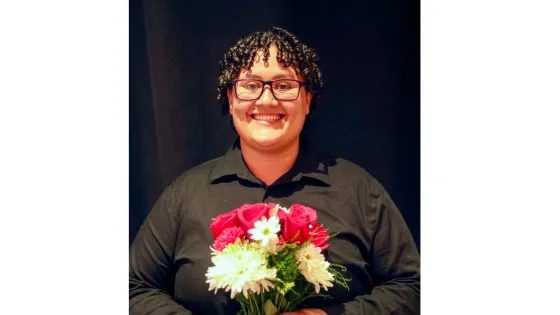 a smiling woman holds flowers