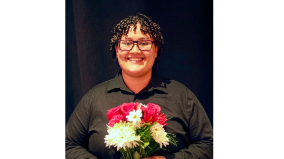 a smiling woman holds flowers