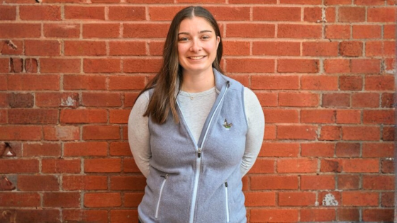 a woman standing in front of a brick wall