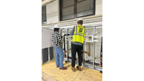 people in hard hats working in a plumbing related lab