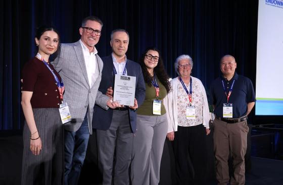 a group of people pose for a photo on a stage