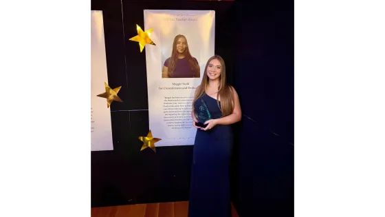 a woman in a black dress holds up an award