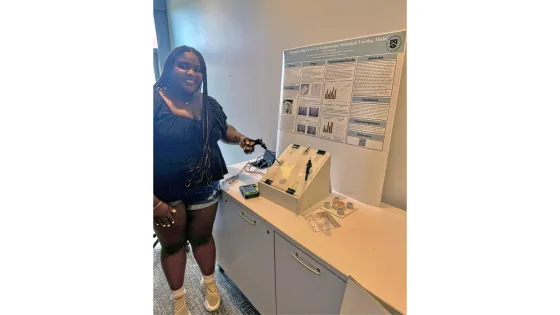 a woman poses with a medical device she created