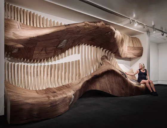 a woman poses near an art installation