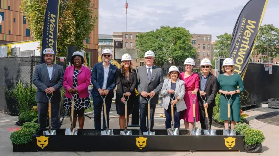 a group of people wearing hard hats and holding shovels